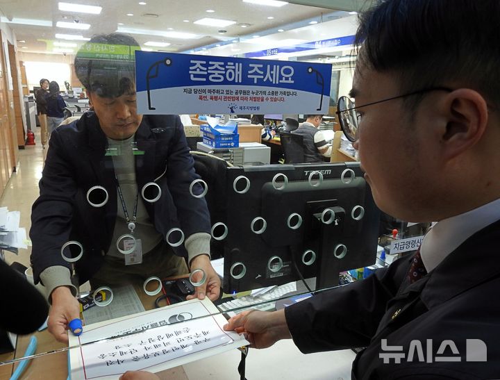 [제주=뉴시스] 김수환 기자 = 9일 오전 김민찬 법률사무소 사활 대표변호사가 제주지방법원 민원실에 쿠팡 개인정보유출사건 피해 제주도민 집단 손해배상청구 소송 소장을 제출하고 있다. 2026.01.09. notedsh@newsis.com