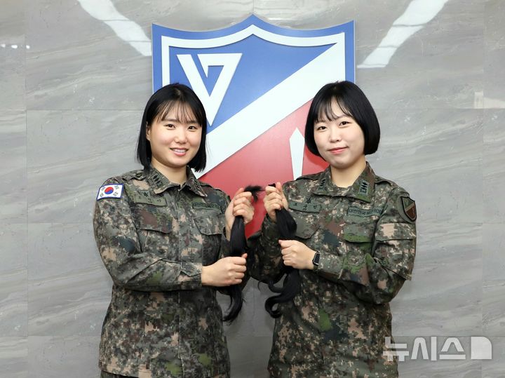 [인천=뉴시스] 육군 17사단 오현아(왼쪽)·조수민 대위가 모발 기부를 위해 자른 머리카락을 들고 기념 촬영하고 있다. (사진=17사단 제공) 2026.01.09. photo@newsis.com