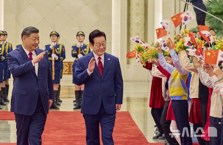 [베이징=뉴시스] 최동준 기자 = 중국을 국빈 방문 중인 이재명 대통령이 5일(현지 시간) 베이징 인민대회당에서 열린 공식환영식에서 시진핑 국가주석과 이동하며 환영 나온 어린이들에게 인사하고 있다. (공동취재) 2026.01.05. photocdj@newsis.com