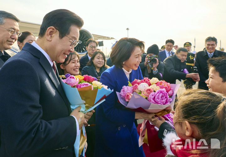 [베이징=뉴시스] 최동준 기자 = 중국을 국빈 방문한 이재명 대통령과 김혜경 여사가 4일(현지 시간) 베이징 서우두 국제공항에 도착해 화동들에게 꽃다발을 받고 있다. (공동취재) 2026.01.04. photocdj@newsis.com