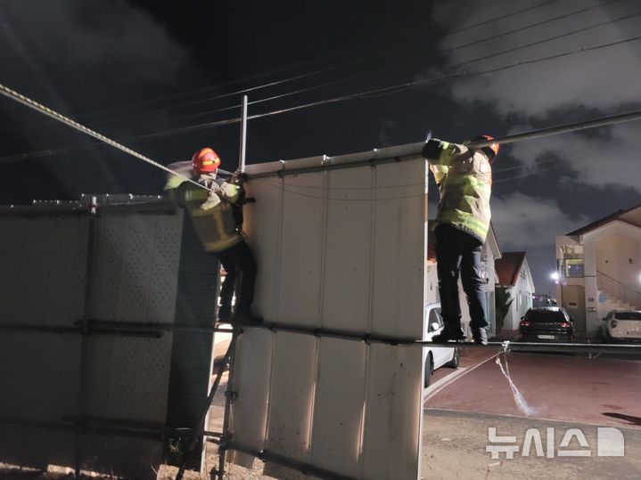 [제주=뉴시스] 지난 10일 오후 제주시 연동에서 119대원이 강풍에 날린 공사장 펜스 고정 작업을 하고 있다. (사진=제주도소방안전본부 제공) 2026.01.11. photo@newsis.com *재판매 및 DB 금지
