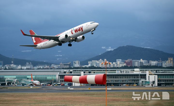[제주=뉴시스] 우장호 기자 = 강풍특보가 발효된 11일 오전 제주국제공항 활주로에서 항공기가 강한 바람을 뚦고 무사히 이륙하고 있다.기상청에 따르면 제주도는 12일 새벽까지 바람이 초속 20m(산지 25m) 이상으로 강하게 불어 항공기 운항에 차질이 예상된다. 2026.01.11. woo1223@newsis.com