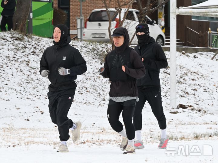 [광주=뉴시스] 이현행 기자 = 밤사이 눈이 쌓인 11일 오전 광주 서구 동천동 광주천변에서 시민들이 달리기를 하고 있다. 이날 오전 광주와 전남 주요지점 최심 적설량은 무안 전남도청 19.7㎝, 목포 14.6㎝, 영암 시종, 12.3 장흥 유치 11.3㎝, 광양 백운산 10.2, 해남 산이 9.6㎝, 신안 압해도 8.5㎝, 장흥 8㎝, 광주 2.7㎝ 이다. 2026.01.11. lhh@newsis.com
