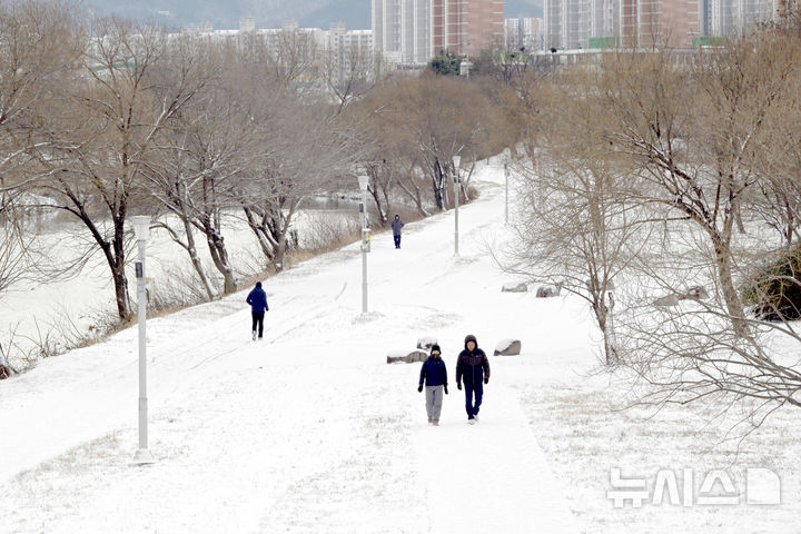 [광주=뉴시스] 이현행 기자 = 밤사이 눈이 쌓인 11일 오전 광주 서구 동천동 광주천변에서 시민들이 걷고 있다. 이날 오전 광주와 전남 주요지점 최심 적설량은 무안 전남도청 19.7㎝, 목포 14.6㎝, 영암 시종, 12.3 장흥 유치 11.3㎝, 광양 백운산 10.2, 해남 산이 9.6㎝, 신안 압해도 8.5㎝, 장흥 8㎝, 광주 2.7㎝ 이다. 2026.01.11. lhh@newsis.com