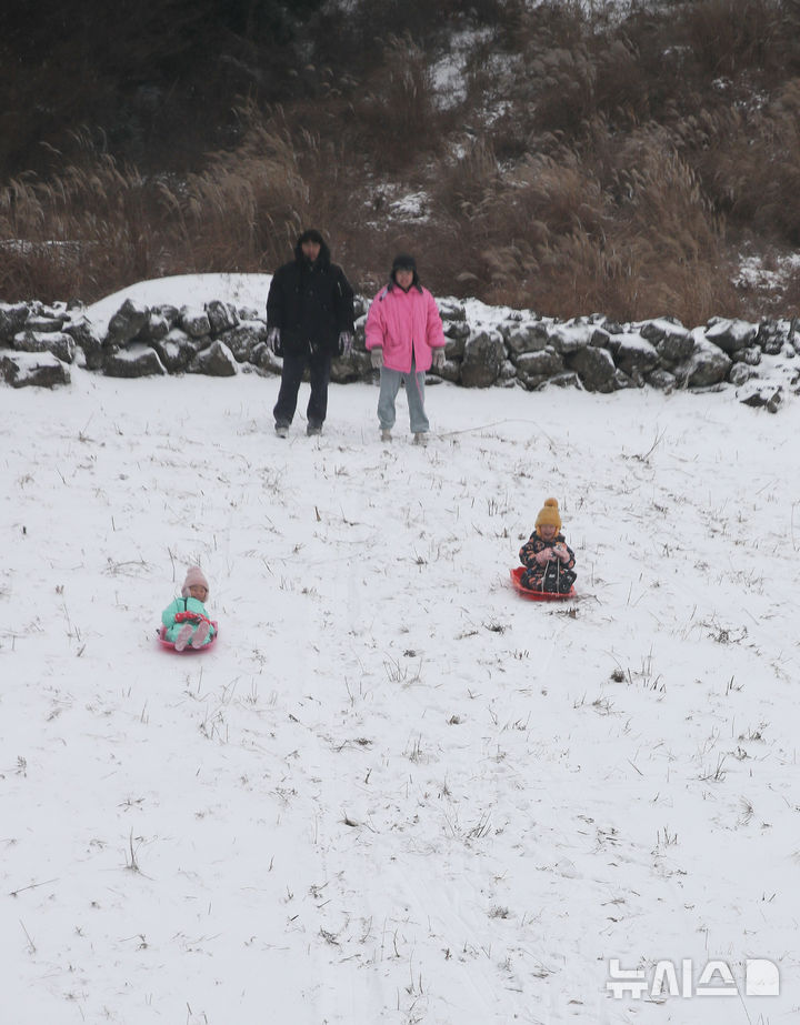 [제주=뉴시스] 우장호 기자 = 제주 산지·중산간·동부·남부에 대설특보가 내려진 11일 오전 제주시 어승생 삼거리 입구 인근 오름에서 어린이들이 썰매를 타고 있다. 기상청에 따르면 제주도는 12일까지 한라산 등 고지대를 중심으로 최대 15㎝의 눈이 내려 쌓일 것으로 예측됐다. 2026.01.11. woo1223@newsis.com