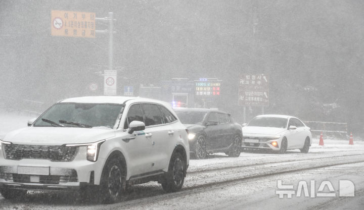 [제주=뉴시스] 우장호 기자 = 제주 산지·중산간·동부·남부에 대설특보가 내려진 11일 오전 제주시 어승생 삼거리 입구에서 제주서부경찰서 소속 경찰관이 도로통제를 하고 있다. 2026.01.11. woo1223@newsis.com