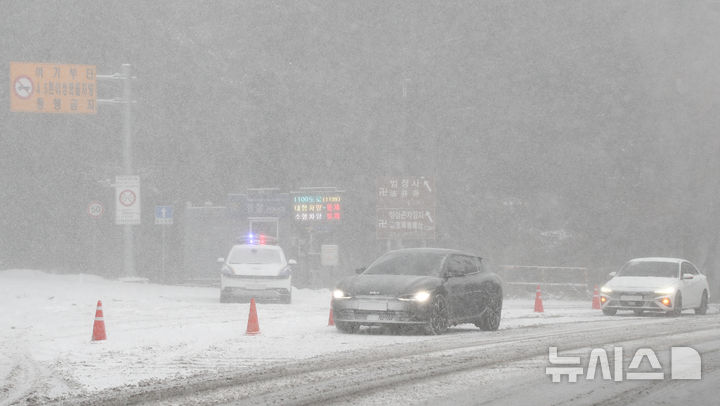 [제주=뉴시스] 우장호 기자 = 제주 산지·중산간·동부·남부에 대설특보가 내려진 지난 11일 오전 제주시 어승생 삼거리 입구에서 제주서부경찰서 소속 경찰관이 도로통제를 하고 있다. 기상청에 따르면 제주도는 12일까지 한라산 등 고지대를 중심으로 최대 15㎝의 눈이 내려 쌓일 것으로 예측됐다. 2026.01.11. woo1223@newsis.com