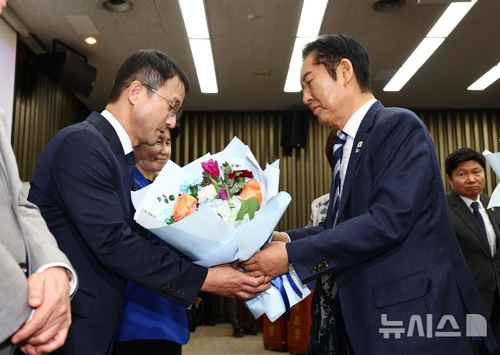 [서울=뉴시스] 김명년 기자 = 정청래 더불어민주당 대표가 11일 오후 서울 여의도 국회에서 열린 의원총회에서 한병도 신임 원내대표에게 꽃다발을 전달하고 있다. 2026.01.11. kmn@newsis.com