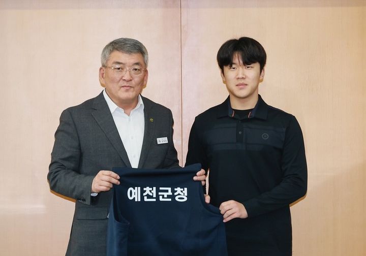 [예천=뉴시스] 김학동 예천군수가 박은성 선수에게 예천군청 양궁선수단 유니폼을 전달하고 있다. (사진=예천군 제공) 2026.01.12. photo@newsis.com *재판매 및 DB 금지