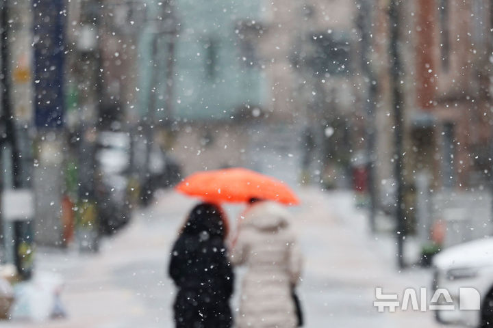 [서울=뉴시스] 권창회 기자 = 서울·인천·경기 서해안에 눈이나 비가 예보된 12일 서울 송파구 주택가에서 시민들이 눈을 맞으며 이동하고 있다. 2025.01.12. kch0523@newsis.com