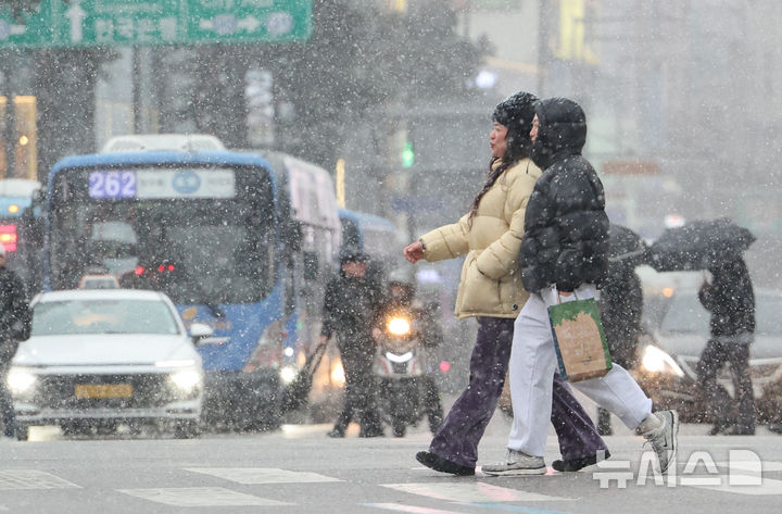 [서울=뉴시스] 황준선 기자 = 12일 오후 서울 중구 을지로에서 시민들이 눈을 맞으며 이동하고 있다. 2026.01.12. hwang@newsis.com