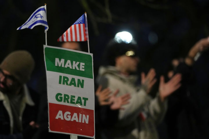 [런던=AP/뉴시스] 지난 12일(현지 시간) 영국 런던의 이란 대사관 밖에서 시위대가 "이란을 다시 위대하게'(MIGA)라고 적힌 손팻말을 들고 있다. 2026.01.14.