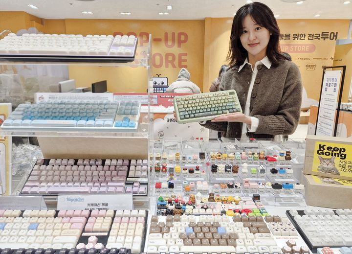 [부산=뉴시스] 롯데백화점 부산본점은 오는 22일까지 지하 1층 시그니처 팝업존에서 100여 종의 키보드를 한자리에서 만날 수 있는 '키덕투어 in 부산' 팝업스토어를 진행한다. 모델이 다양한 커스텀 키보드와 액세서리를 선보이는 모습. (사진=롯데백화점 부산본점 제공) 2026.01.13. photo@newsis.com *재판매 및 DB 금지