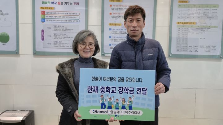 [서울=뉴시스] 한솔그룹 계열 골판지 원지 제조기업 한솔페이퍼텍이 사업장 인근 초·중학교 졸업식을 맞아 장학금을 전달하며 지역사회 나눔을 이어갔다. 사진은 장학금을 전달한 뒤 기념촬영을 하고 있는 한솔페이퍼텍 HR지원팀 남윤갑 팀장(오른쪽)과 한재중학교 양사라 교장 모습. (사진=한솔그룹 제공) 2026.01.13 photo@newsis.com *재판매 및 DB 금지