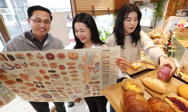 [대전=뉴시스] 조명휘 기자 = 박희조(왼쪽) 대전 동구청장 등이 마을 빵집 영문지도 'Bread City Donggu'를 살펴보고 있다. (사진= 동구청 제공) 2026.01.13. photo@newsis.com *재판매 및 DB 금지