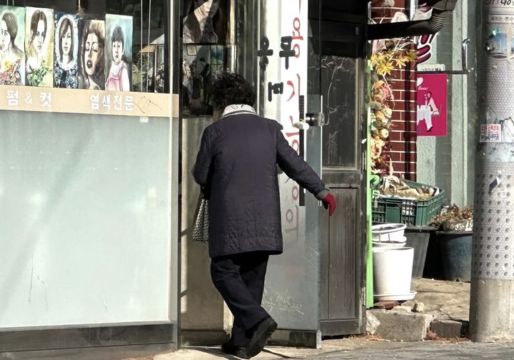 [서울=뉴시스] 한민아 인턴기자= 한 손님이 오래된 미용실 문을 열고 들어가고 있다. 2026.01.13. *재판매 및 DB 금지