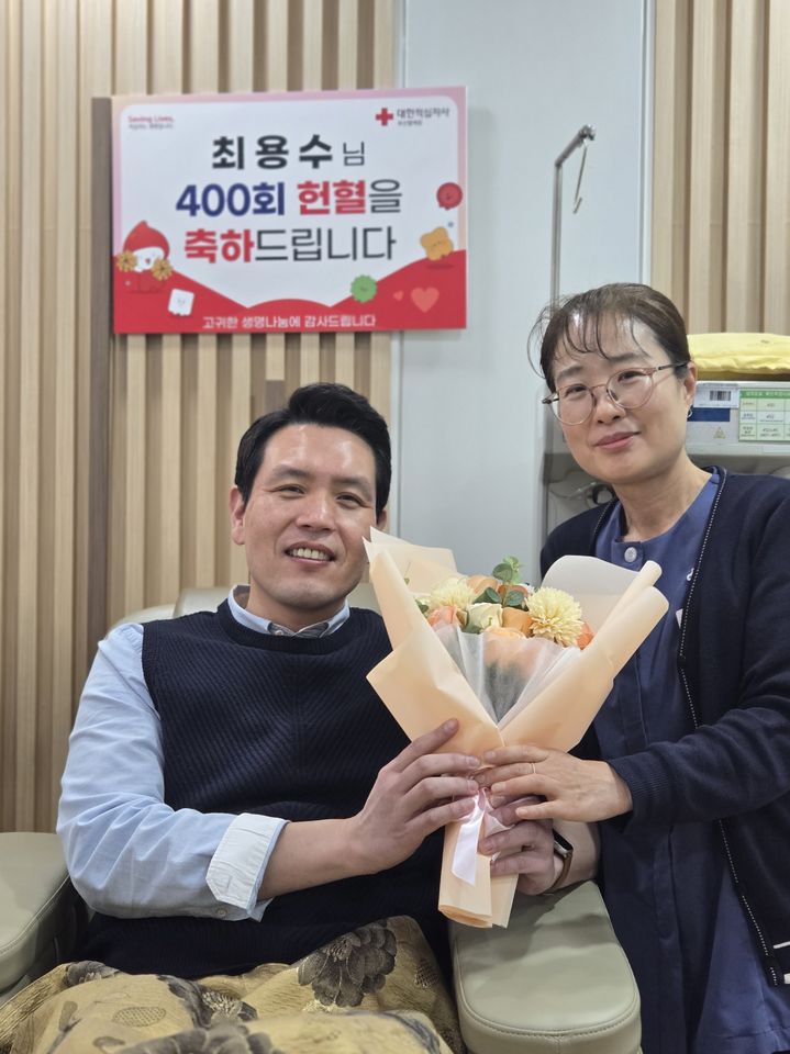 [부산=뉴시스] 13일 부산 지역에서 400회 헌혈자가 탄생했다고 밝혔다. 최용수씨(왼쪽)가 이날 부산 남구 대연 헌혈의 집에서 400번째 헌혈을 마치고 꽃다발을 받고 있다. (사진=부산혈액원 제공) 2026.01.13. photo@newsis.com *재판매 및 DB 금지