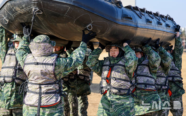 [포항=뉴시스] 이무열 기자 = 13일 경북 포항시 해병대 1사단 연병장에서 열린 ‘2026 겨울 해병대 캠프'에서 참가자들이 소형 고무보트(IBS)를 머리에 이고 이동하고 있다. 2026.01.13. lmy@newsis.com