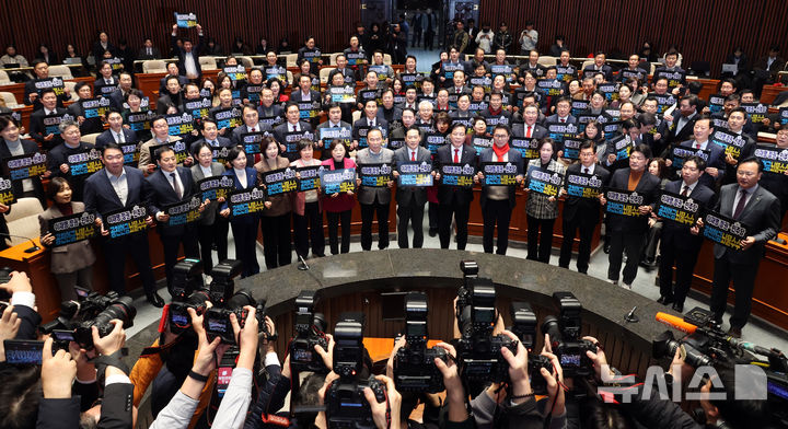 [서울=뉴시스] 김금보 기자 = 국민의힘 장동혁 대표, 송언석 원내대표, 당협위원장, 국회의원들이 13일 오후 서울 여의도 국회에서 열린 의원총회에서 '이재명 정권-더불어민주당 공천헌금·뇌물수수 규탄' 손피켓을 들고 구호를 외치고 있다. 2026.01.13. kgb@newsis.com