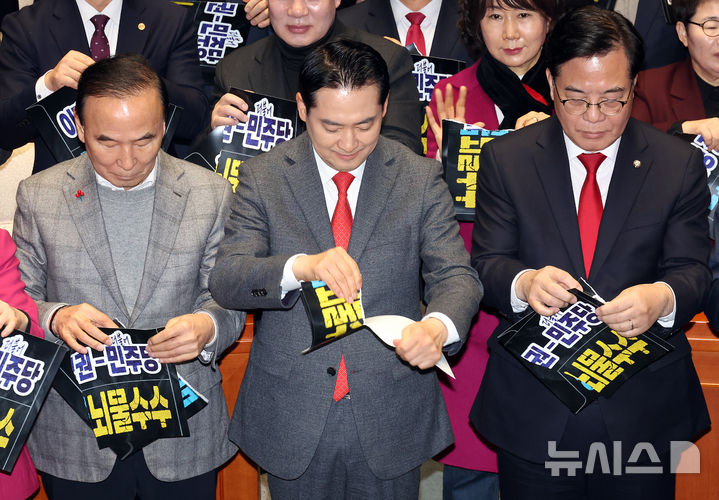 [서울=뉴시스] 김금보 기자 = 국민의힘 장동혁 대표, 송언석 원내대표, 당협위원장, 국회의원들이 13일 오후 서울 여의도 국회에서 열린 의원총회에서 '이재명 정권-더불어민주당 공천헌금·뇌물수수 규탄' 손피켓을 찢는 퍼포먼스를 하고 있다. 2026.01.13. kgb@newsis.com