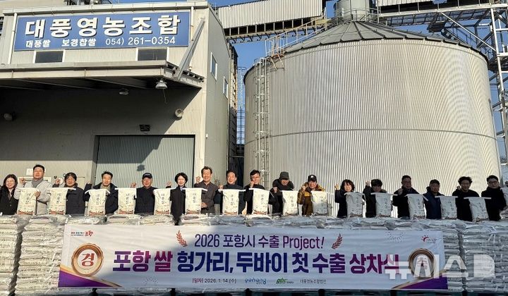 [포항=뉴시스] 송종욱 기자 = 14일 북구 흥해읍 대풍영농조합법인에서 포항 쌀을 헝가리와 아랍에미리트로 수출하기 위해 차에 실으며 시와 법인 관계자, 농업인이 기념 촬영하고 있다. (사진=포항시 제공) 2026.01.14. photo@newsis.com 