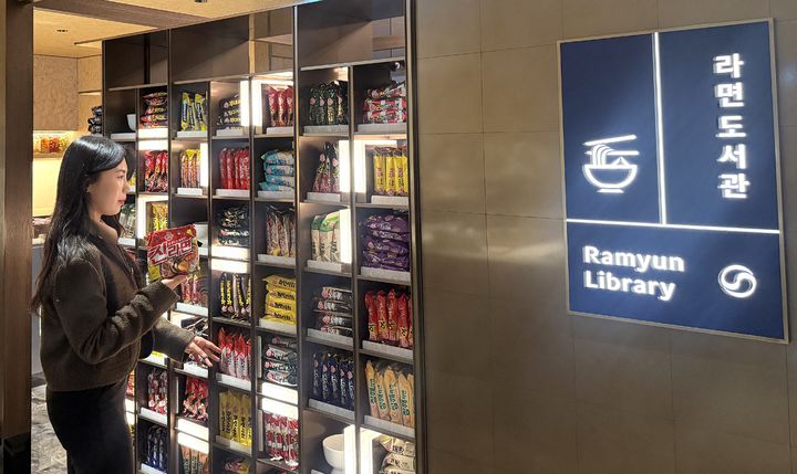 [서울=뉴시스] 한 방문객이 다양한 라면이 진열된 '라면도서관'을 구경하고 있다. (사진=오뚜기 제공) 2026.01.14. photo@newsis.com *재판매 및 DB 금지