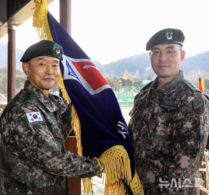 [인천=뉴시스] 14일 오후 인천 부평구 육군 제17보병사단 대연병장에서 열린 제44대·45대 사단장 이·취임식에서 김용수 신임 사단장(오른쪽)이 이임수 수도군단장으로부터 부대기를 이양받고 있다. (사진=17사단 제공) 2026.01.14. photo@newsis.com