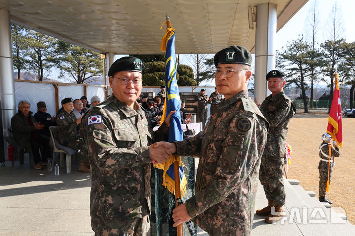 [증평=뉴시스] 김경수 신임 37사단장(오른쪽)이 14일 부대에서 김호복 2작전사령관으로부터 부대기를 전달받고 있다. (사진=육군 37사단 제공) 2026.01.14. photo@newsis.com 