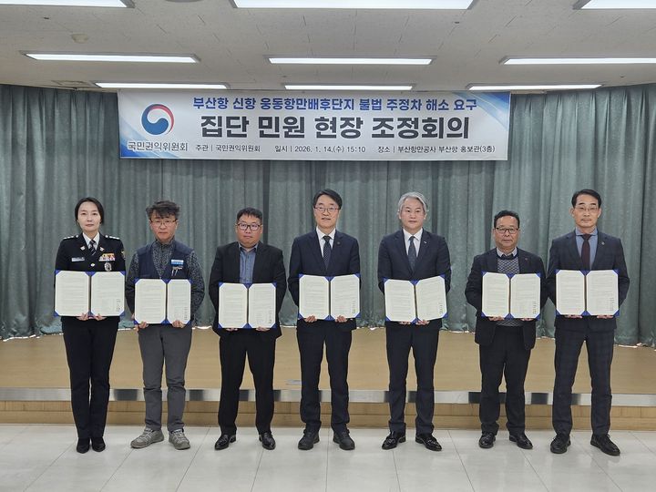 [창원=뉴시스] 강경국 기자 = 14일 부산항만공사 부산항 홍보관에서 부산항 신항 웅동항만 배후단지 불법 주정차 해소 요구 집단 민원 현장 조정회의가 열린 가운데 국민권익위원회, 경상남도, 부산항만공사, 진해경찰서, 컨테이너위수탁본부 관계자가 조정서에 서명을 한 후 기념촬영을 하고 있다. (사진=창원시청 제공). 2026.01.14. photo@newsis.com *재판매 및 DB 금지