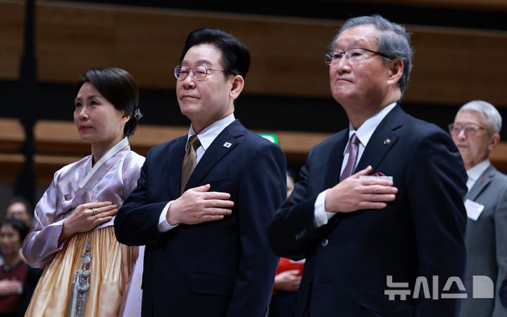 [나라=뉴시스] 고범준 기자 = 이재명 대통령과 김혜경 여사가 14일(현지 시간) 일본 나라현의 한 호텔에서 열린 간사이 동포 간담회에서 국민의례를 하고 있다. 오른쪽은 김명홍 재일민단 오사카본부 단장. 2026.01.14. bjko@newsis.com