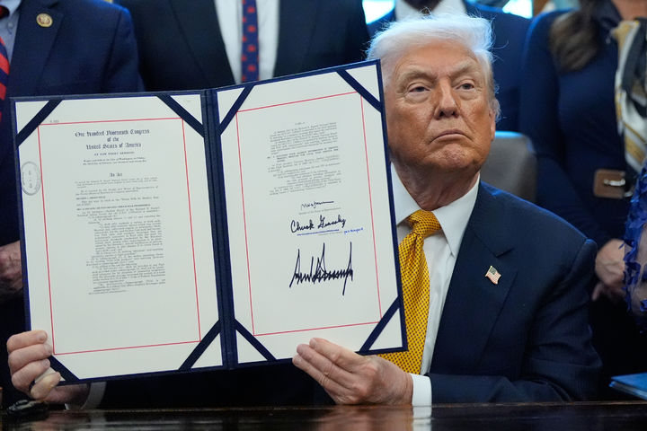 [워싱턴=AP/뉴시스] 도널드 트럼프 미국 대통령이 14일(현지 시간) 백악관 집무실에서 전국 공립학교 급식에 일반 우유(whole milk·전유) 제공을 재도입하는 법안에 서명 후 이를 들어 보이고 있다. 2026.01.15.