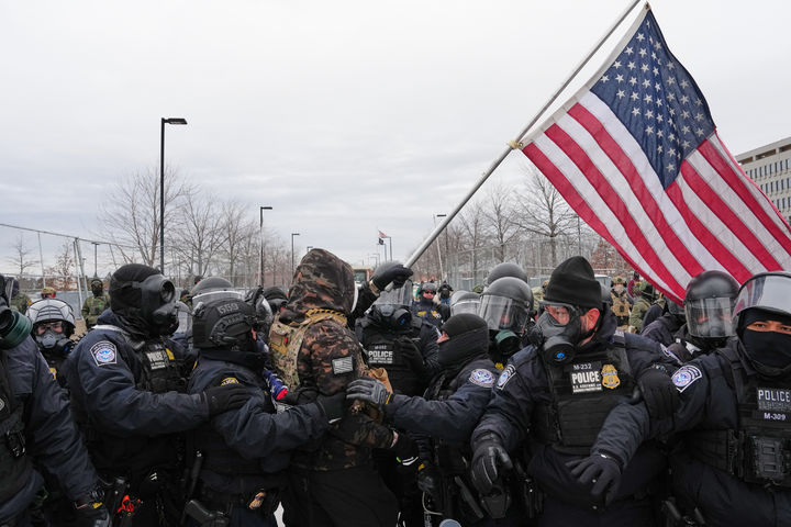[미니애폴리스=AP/뉴시스]15일(ㅎ녀지 시간) 미국 미네소타주 미니애폴리스 헨리 위플 연방청사 건물 앞에서 미국 국기를 흔들며 시위하던 남성이 경찰에 체포되고 있다. 2026.01.16.