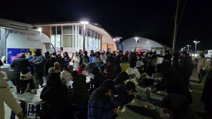 [서울=뉴시스] 40여 명이 한 번에 앉을 수 있는 행사장 좌석에서 사람들이 떡국을 먹고 있다. 2026.01.01. *재판매 및 DB 금지