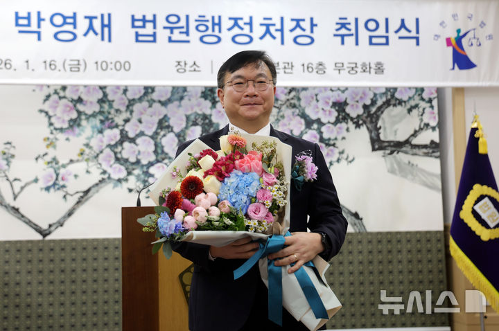 [서울=뉴시스] 홍효식 기자 = 박영재 신임 법원행정처장이 16일 서울 서초구 대법원에서 열린 취임식에서 꽃다발을 받고 기념촬영하고 있다. 2026.01.16. yesphoto@newsis.com