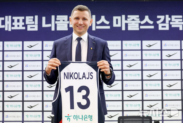 [서울=뉴시스] 김진아 기자 = 남자농구 국가대표팀 니콜라이스 마줄스(Nikolajs Mazurs) 감독이 16일 서울 중구 프레스센터에서 열린 취임 기자회견에서 유니폼을 들고 기념촬영을 하고 있다. 2025.01.16. bluesoda@newsis.com