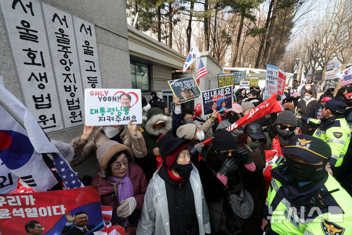 [서울=뉴시스] 홍효식 기자 = 윤석열 전 대통령의 체포영장 집행 방해 혐의 등 1심 선고기일인 16일 오후 서울 서초구 서울중앙지방법원 인근에서 지지자들이 '윤 어게인'을 외치고 있다. 2026.01.16. yesphoto@newsis.com