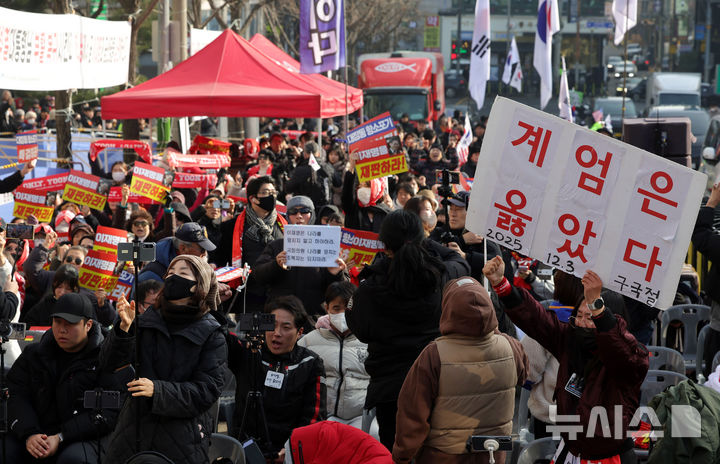 [서울=뉴시스] 홍효식 기자 = 윤석열 전 대통령이 체포영장 집행 방해 혐의 등 1심 선고에서 징역 5년을 선고 받은 16일 오후 서울 서초구 서울중앙지방법원 인근에서 윤 전 대통령 지지자들이 선고 생중계를 시청하며 구호를 외치고 있다. 2026.01.16. yesphoto@newsis.com