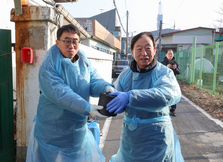 [대전=뉴시스] 소외계층을 위한 연탄나눔 봉사활동에서 연탄을 나르는 설동호(오른쪽) 대전시교육감과 채정일 노조위원장. (사진=대전시교육청 제공) 2026.01.17. photo@newsis.com *재판매 및 DB 금지