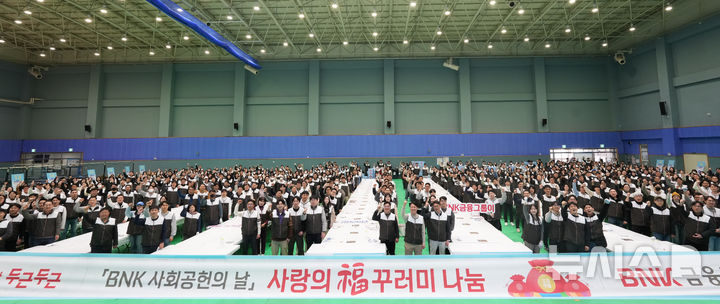 [창원=뉴시스]17일 오전 경남 창원축구센터 실내체육관에서 BNK경남은행 김태한 은행장과 임직원들이 2026년 제1차 BNK금융그룹 사회공헌의 날을 맞아 저소득층에 나눠줄 ‘복(福)꾸러미’ 제작에 앞서 기념촬영을 하고 있다.(사진=BNK경남은행 제공) 2026.01.17. photo@newsis.com