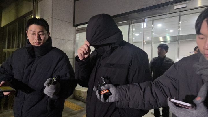 [서울=뉴시스] 이지영 기자=18일 오후 11시17분께 조사를 마친 남씨가 외투에 달린 모자를 눌러쓰고 고개를 숙인 채 나오고 있다. 2026.01.18 *재판매 및 DB 금지