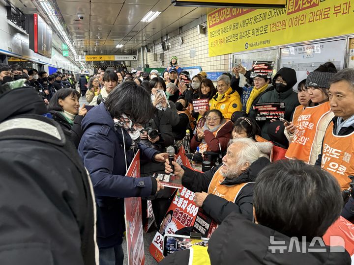 [서울=뉴시스]신유림 기자=전국장애인차별철폐연대(전장연) 박경석 대표가 출근길 지하철 선전전 1000일을 맞아 19일 서울 종로구 지하철 4호선 혜화역 승강장에서 집회를 열고 정보라 작가에게 감사패를 수여하고 있다. 2025.01.19 spicy@newsis.com 