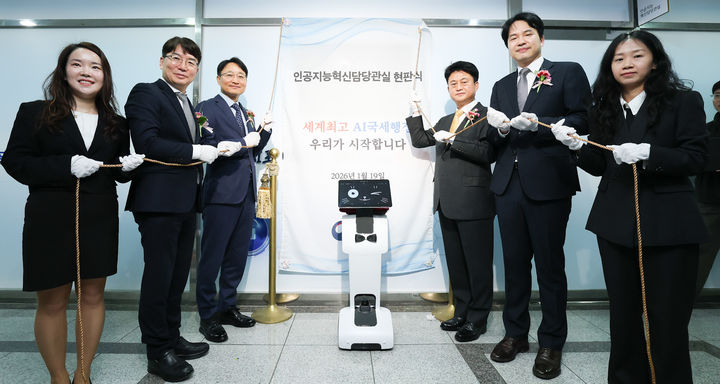 임광현 국세청장(왼쪽에서 세번째)이 19일 세종시 나성동 SM타워에서 열린 AI혁신담당관실 현판식에서 양철호 정보화담당관(왼쪽에서 두번째), 이성진 차장(오른쪽에서 세번째), 전승한 AI혁신담당관(오른쪽에서 두번째), K-AI 로봇(가운데)과 기념촬영을 하고 있다.(사진 : 국세청 제공) 2026.1.19. *재판매 및 DB 금지