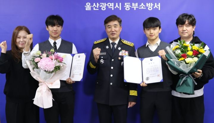 [울산=뉴시스] 울산 동부소방서가 19일 서장실에서 문현서·윤재준 군에게 표창장을 전달한 뒤 기념촬영을 하고 있다. 2026.01.19. (사진=동부소방 제공) photo@newsis.com *재판매 및 DB 금지