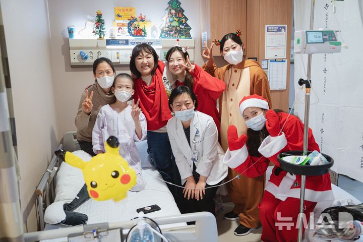 [서울=뉴시스] 이수지씨(왼쪽 세번째)와 김아영씨(왼쪽 네번째)가 소아 환자, 의료진(가운데, 권승연 소아혈액종양과 교수)과 함께 사진을 촬영하고 있다. (사진= 세브란스병원 제공)