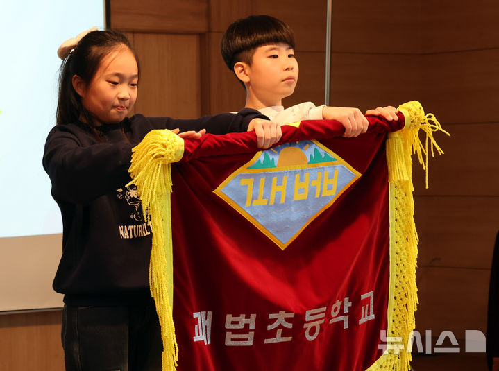 [부산=뉴시스] 하경민 기자 = 부산 사상구 괘법초등학교가 저출산, 학령인구 감소 등으로 인근 학교와 통·폐합이 확정된 가운데 20일 학교 강당에서 열린 이별식에 참석한 학생 대표들이 교기를 반납하고 있다. 1982년 3월5일 28학급(학생 1261명)으로 개교한 괘법초는 지난해 전교생 52명의 소규모 학교로 운영, 인근 감전초등학교와 통·폐합이 확정됐다. 괘법초를 비롯해 올해 부산에서 통·폐합되는 초등학교는 영도구 봉삼초 및 신선초 등 총 3곳이다. 2026.01.20. yulnetphoto@newsis.com