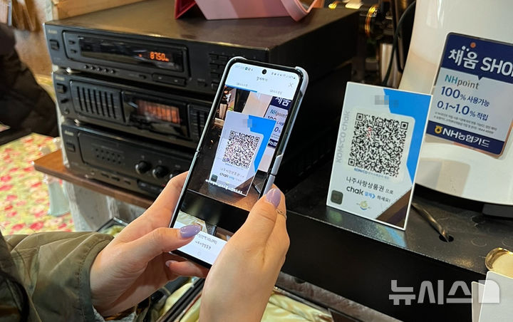 [나주=뉴시스] 한 소비자가 요식업소에서 나주사랑상품권으로 결제하고 있다. (이미지=나주시 제공) photo@newsis.com *재판매 및 DB 금지