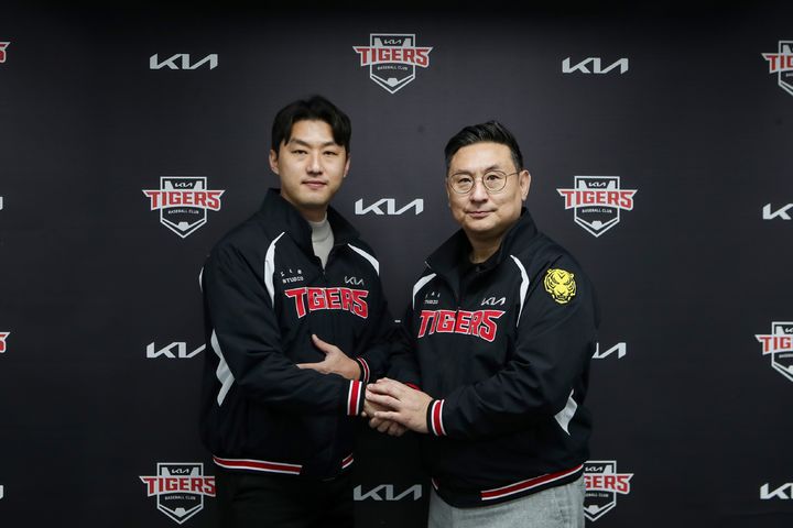 [서울=뉴시스] 홍건희(왼쪽)와 심재학 KIA 타이거즈 단장이 계약을 체결한 뒤 기념 사진을 찍고 있다. (사진=KIA 타이거즈 제공) 2026.01.21. *재판매 및 DB 금지
