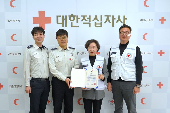 [울산=뉴시스] 21일 대한적십자사 울산광역시지사에서 열린 소방청장 표창장 수여식에서 울산소방본부 이장희 대응총괄팀장, 대한적십자사 울산광역시지사 김남희 사무처장·유태균 구호봉사팀장과 관계자가 기념촬영하고 있다. (사진=대한적십자사 울산광역시지사 제공) 2026.01.21. photo@newsis.com *재판매 및 DB 금지