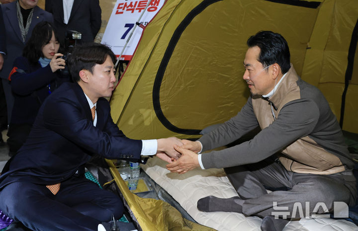 [서울=뉴시스] 고승민 기자 = 장동혁 국민의힘 대표가 21일 오전 서울 여의도 국회 로텐더홀에서 '민주당의 공천 뇌물·통일교 게이트 특검 수용'을 촉구하며 단식농성 중 이준석 개혁신당 대표와 대화를 하며 손을 잡고 있다. (공동취재) 2026.01.21. photo@newsis.com