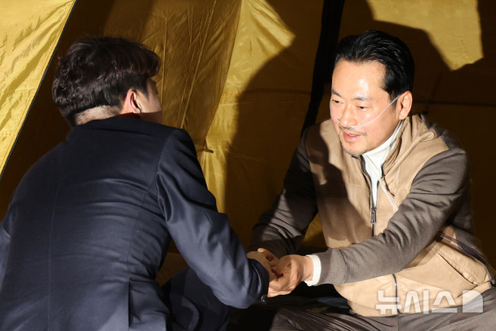 [서울=뉴시스] 김금보 기자 = 이준석 개혁신당 대표가 21일 오전 서울 여의도 국회 로텐더홀에서 '민주당 공천 뇌물·통일교 게이트 특검' 수용 촉구 단식투쟁을 하는 장동혁 국민의힘 대표를 찾아 악수하고 있다. 2026.01.21. kgb@newsis.com